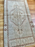 Measures 1'8" x 3'3"  Palette includes green tones, brown and a shimmery tan   Vintage Turkish, handmade of wool 