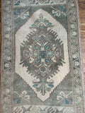 Dimensions: 1'10" x 3'3"  Palette includes shades of green, muted brunette, and beige.   Vintage Turkish c.1960, handmade of wool. 