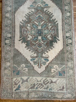 Dimensions: 1'10" x 3'3"  Palette includes shades of green, muted brunette, and beige.   Vintage Turkish c.1960, handmade of wool. 
