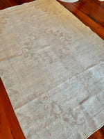 Measures 4'6.5" x 7.5'  Palette includes steel blue, pops of pink, cinnamon, and beige  Vintage Turkish rug approximately 60 years old, handmade of wool 