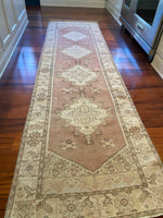 Dimensions: 2'6.5" x 9'1"  Palette includes a muted pink with more brown and red undertones versus true pink, blue, green, ecru, light yellow, and brown in the thin lines around the patterns.  This is a vintage Turkish runner from the 1940's made of 100% soft organic wool. It has been professionally cleaned. 