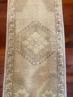 Dimensions: 1'5.5" x 3'4"  Palette includes parchment, hints of blue, and walnut.  Vintage Turkish approx. 50 years old, handmade of wool.   These photos were taken indoors with overhead lights on.  